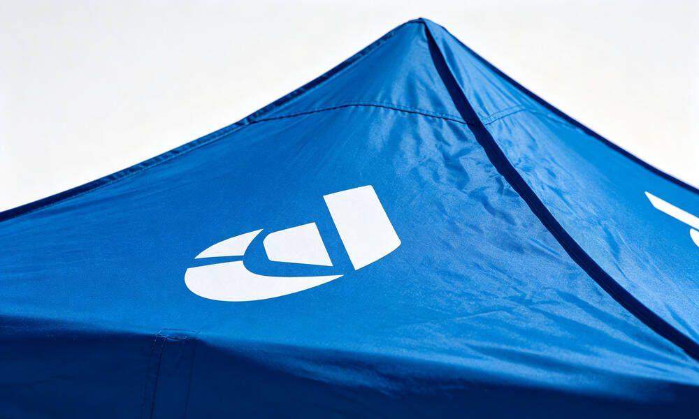 Close-up of custom logo printing on emergency tent fabric showing heat transfer print quality for branding