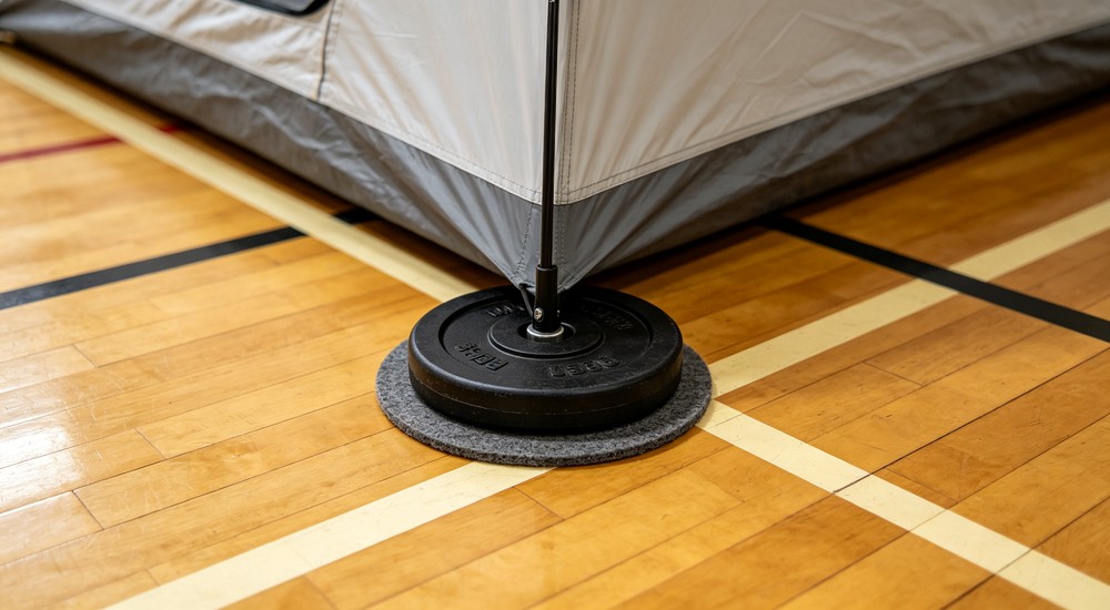 Hard floor stability solution for indoor shelter tent with weight plate