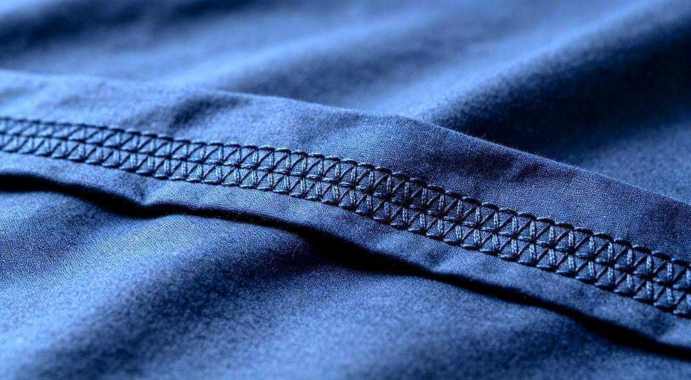 Reinforced stitching navy detail showing navy and grey institutional bedding for remote worker accommodation and industrial camp facilities