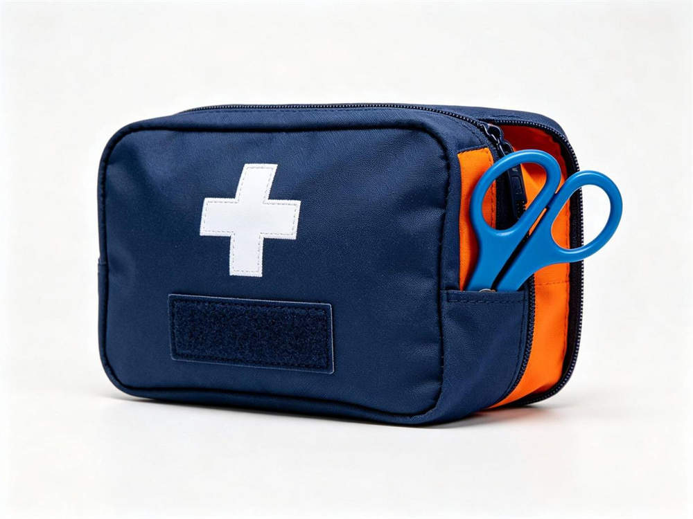 Product shot of navy blue custom marking medical pouch with white cross emblem blank velcro patch area orange interior visible blue scissors attached white background