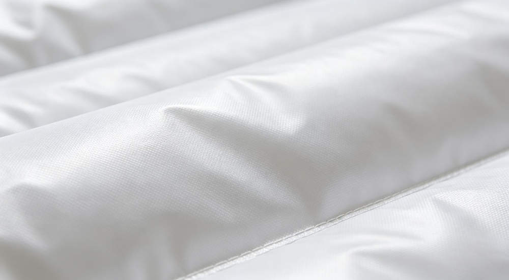 High-quality photo of a 30 square meter inflatable medical tent detailed close-up view showing material texture showing durable waterproof, fire retardant, and UV resistant PVC fabric material in white color with red cross medical markings