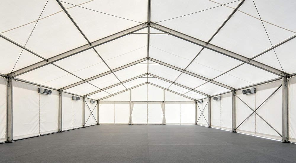 Wide panoramic view of a large humanitarian relief camp with dozens of emergency tents organized in neat rows demonstrating scale of disaster response operations