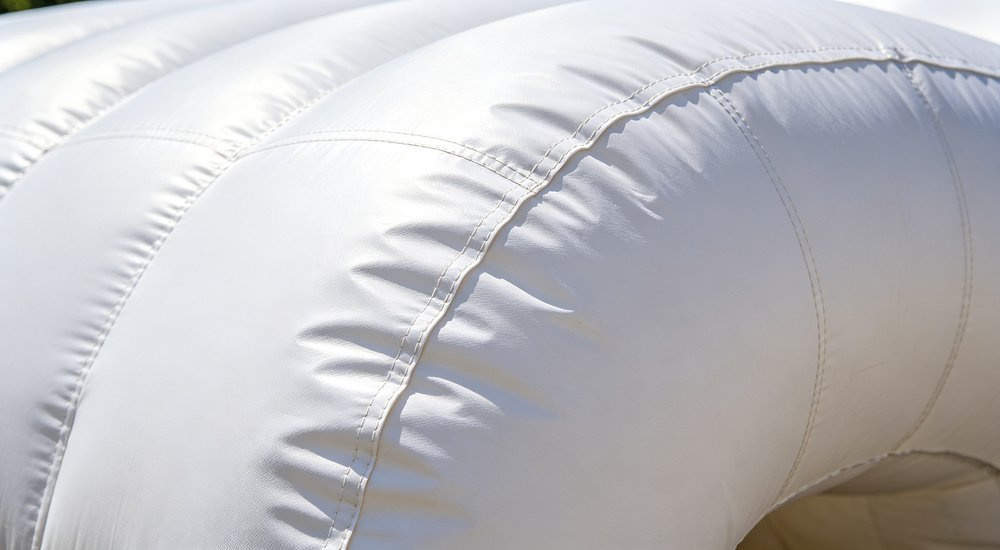 Close-up detail of inflatable tent air beam structure showing thick PVC fabric, bright lighting red and white inflatable emergency shelter for disaster relief operations