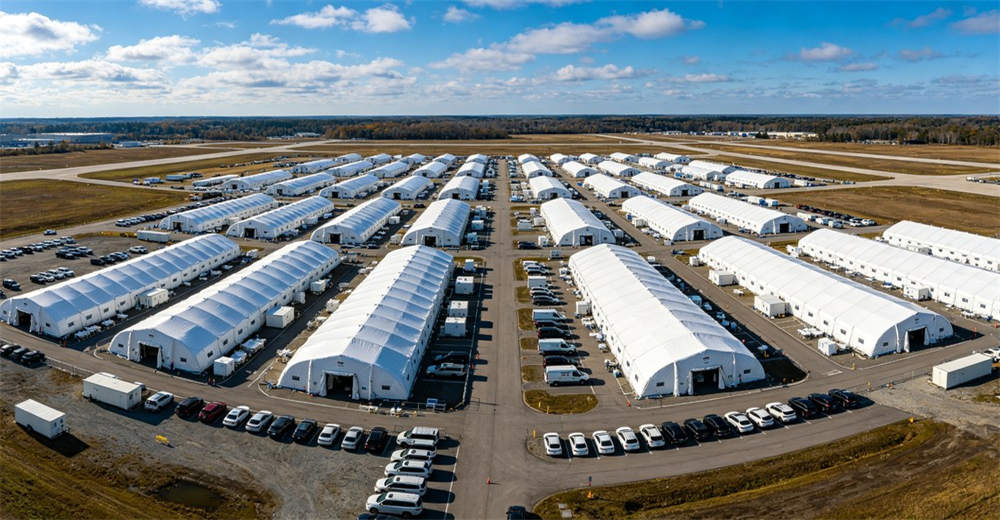 Aerial drone view of temporary field hospital complex with multiple medical tents organized Aerial drone view of temporary field hospital complex with multiple medical tents organized