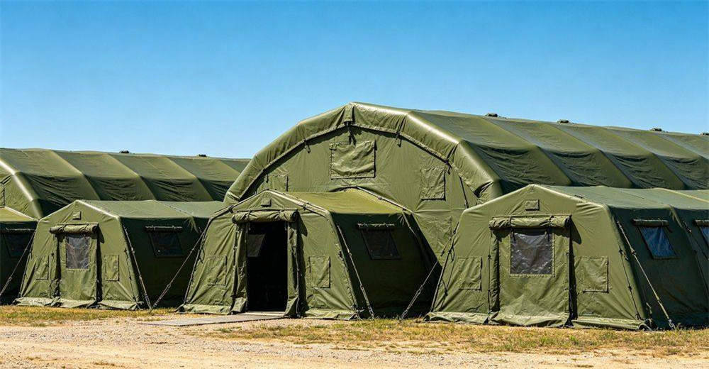 Multiple inflatable tents combined into modular camp system, showing interconnected command, living and logistics units with connecting corridors, demonstrating scalable field shelter solution for varying operational requirements