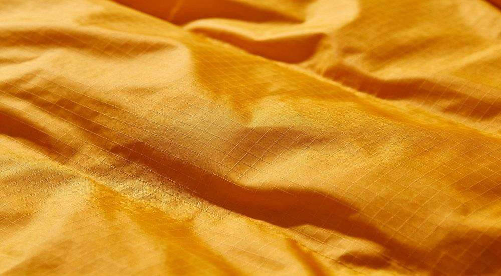 Close up of ripstop sleeping bag fabric texture anti-tear grid pattern durable outer shell material macro