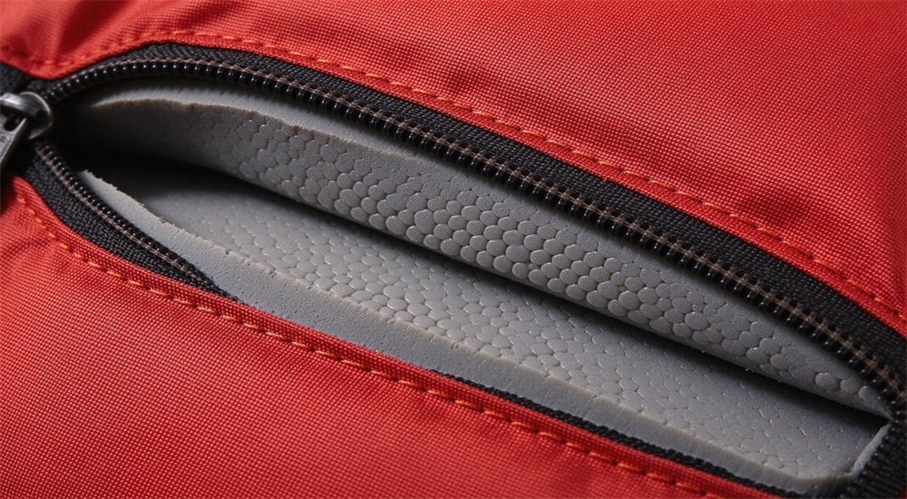Macro close-up of NBR PVC closed-cell foam cross-section inside water rescue life jacket showing Cordura nylon outer shell precise stitching and zipper construction detail