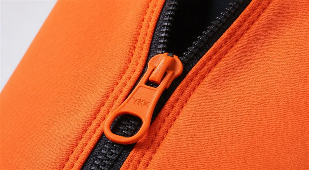 Close-up product detail of YKK corrosion resistant front zipper on orange neoprene wetsuit showing quick donning diagonal entry design with pull tab for rapid deployment in emergency response Close-up product detail of YKK corrosion resistant front zipper on orange neoprene wetsuit showing quick donning diagonal entry design with pull tab for rapid deployment in emergency response