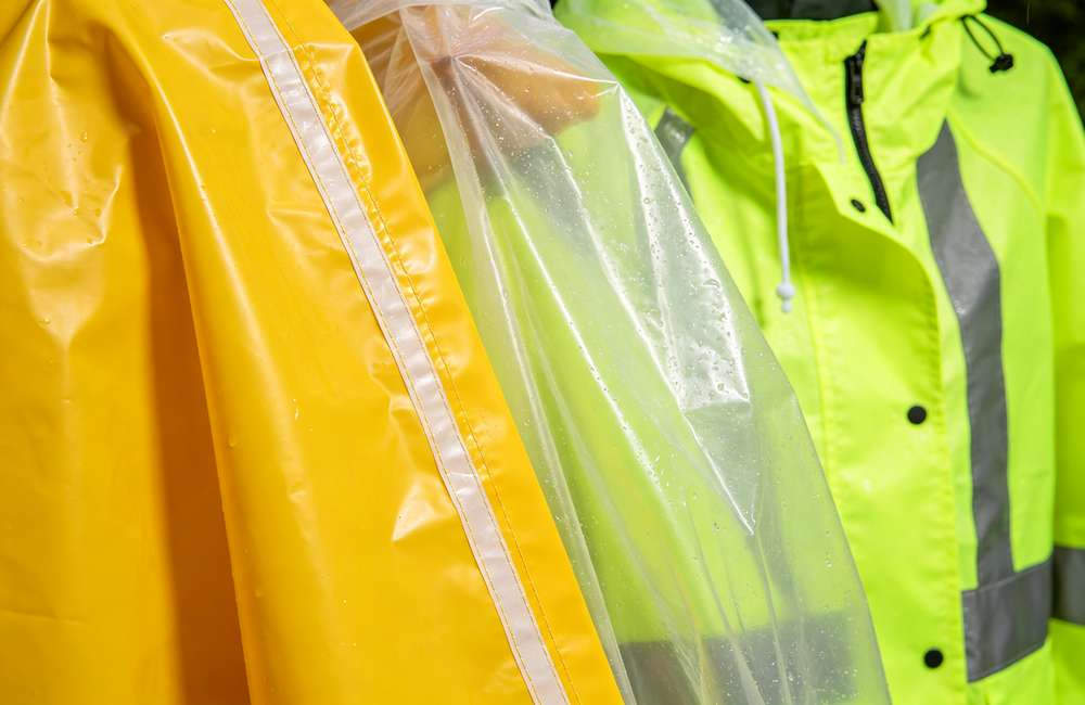 Three rain poncho material samples compared: thin PE, 0.12mm PVC, heavy-duty PU with taped seams, showing thickness differences for buyers.