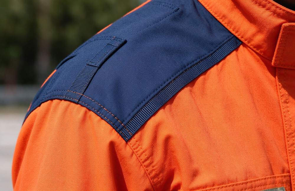 Detail view view of rescue suit stretch panel detail showing elastic insert for technical orange with yellow reflective trim rescue clothing movement freedom and rescue clothing active comfort design