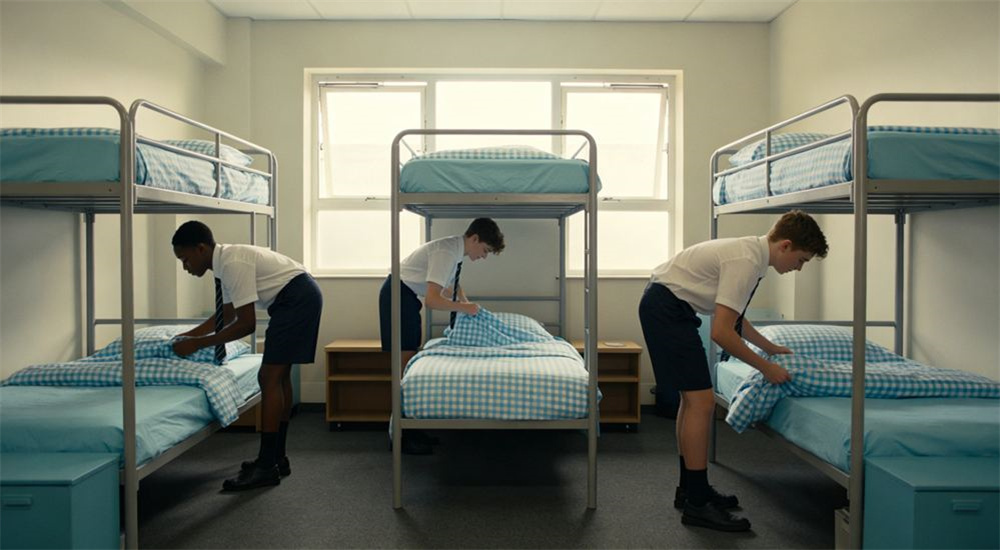 Overhead view of warm boarding school dormitory room with two single beds dressed in matching navy and white linen, comfortable durable wholesale school dormitory bedding chosen for K 12 students and shared rooms