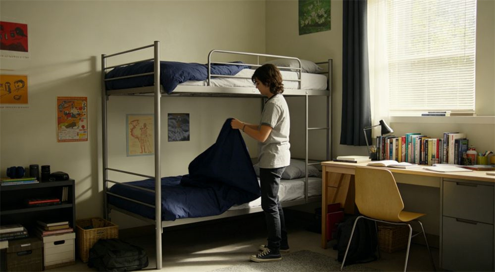 Top-down view of bright tidy fully outfitted dormitory room with matching blue and white institutional bedding on single beds, wholesale school dormitory bedding ready for student move in day and welcome week, across university residence halls and boarding school houses.