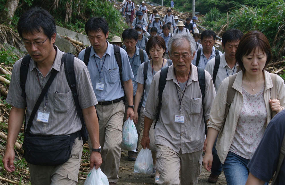 Diverse group of people walking uphill on evacuation path after tsunami warning, carrying bags and emergency supplies, evacuation gear kit in use.