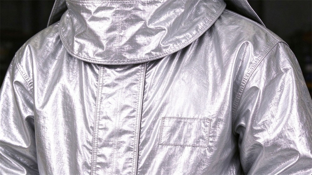 Wide shot of heavy duty protective aluminized heat protective suit, Aluminized heat protective suit with custom logo branding on chest detail, steel, demonstrating professional product use in industrial safety environment, designed for wholesale bulk supply and industrial safety procurement.