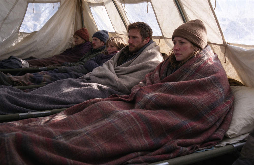 Relief shelter tent interior with people sitting together under blankets, emergency shelter warmth solutions for carbon monoxide risk reduction and cold weather disaster relief for displaced residents
