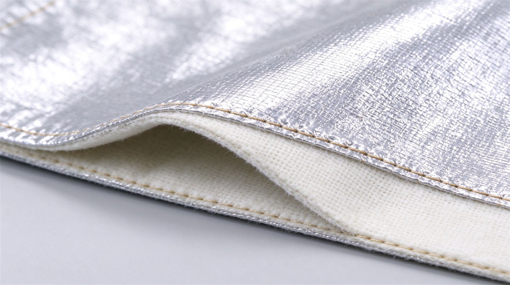 Overhead view of heavy duty protective high temperature insulated coverall, Silver reflective fabric stitching detail of the heat insulation coverall, multi-layer heat, demonstrating professional info use in industrial safety environment, designed for wholesale bulk supply and industrial safety procurement.