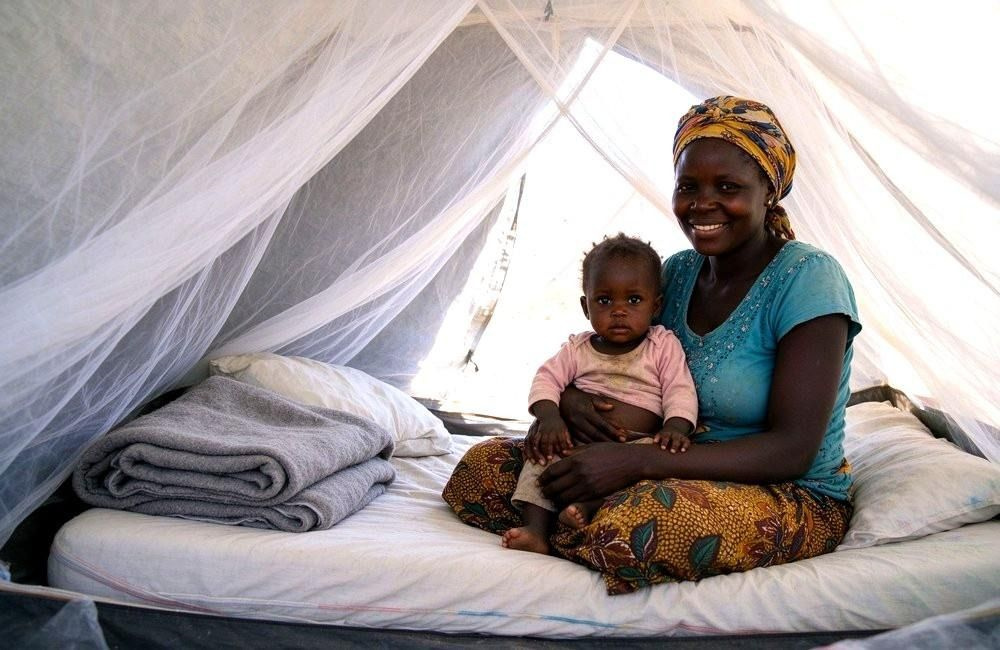 Mosquito net covering a family sleeping area inside a tent after flooding, showing mosquito nets after flood protecting households in post-flood malaria prevention
