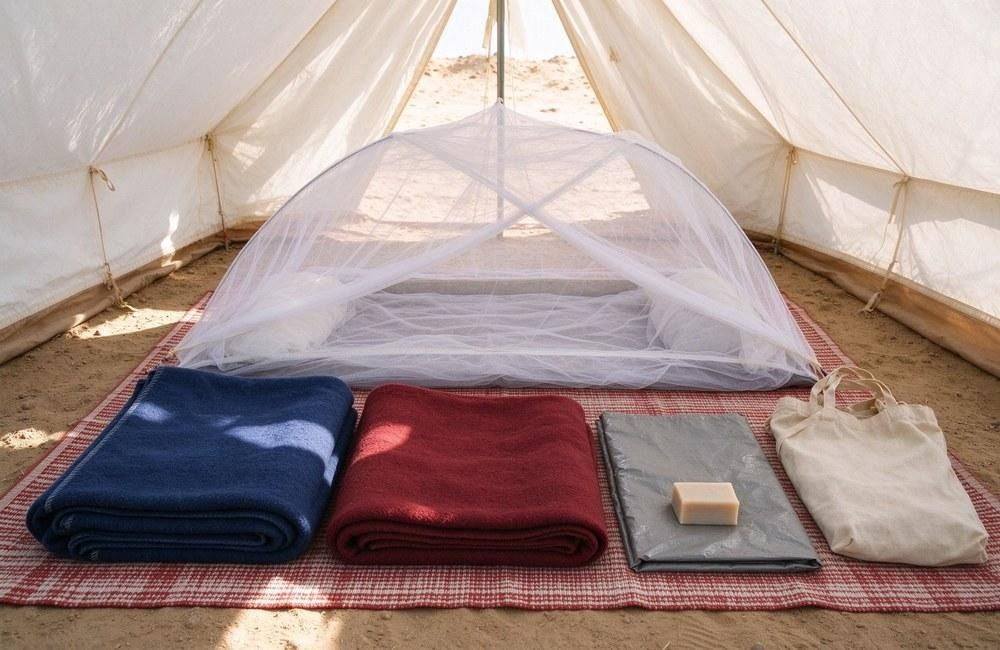 Full disease prevention kit laid out with treated mosquito net, blanket, soap, water purification tablets and carry bag, showing mosquito nets bulk in family kits