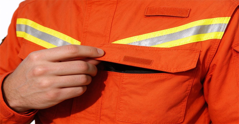 Zippered chest pocket on fire suit with hook and loop flap for secure storage of small essentials Zippered chest pocket on fire suit with hook and loop flap for secure storage of small essentials