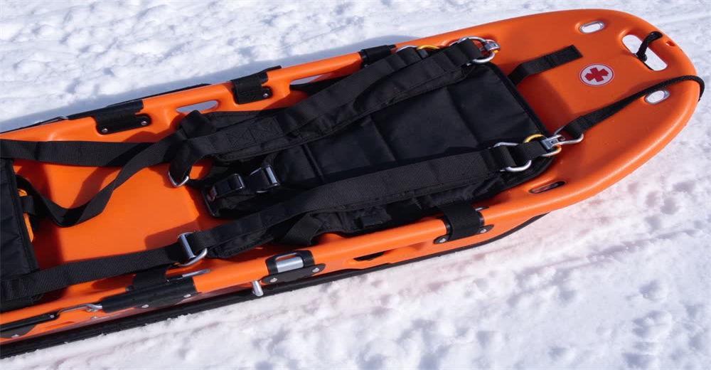 Front view of blue alpine rescue sled showing specialized patient evacuation sled for snowy terrain Front view of blue alpine rescue sled showing specialized patient evacuation sled for snowy terrain