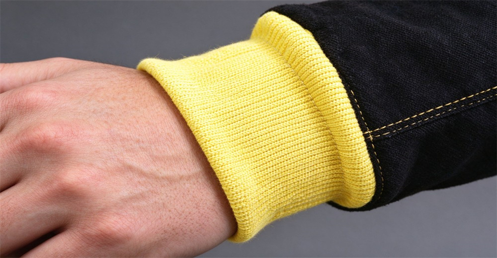 Close up view of fire resistant protective glove featuring stretch yellow knitted cuff and black leather outer layer with neat stitching