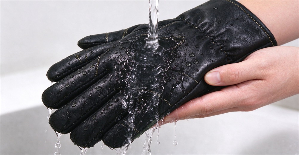 Water flows over the surface of black fire protective glove to demonstrate its water resistant performance
