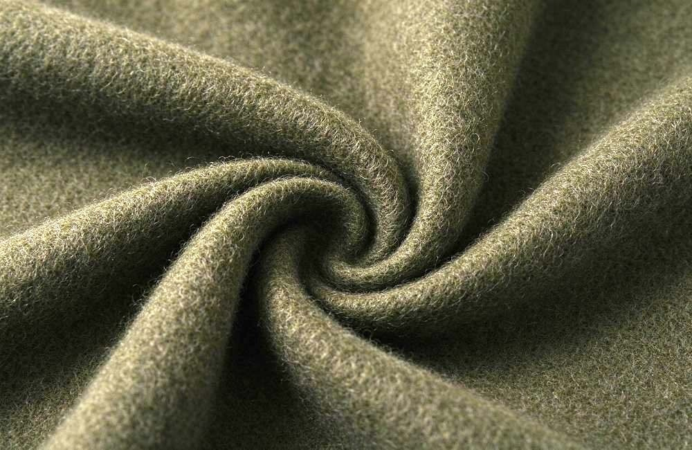 Macro close-up shot of brushed olive wool blend emergency blanket fabric with soft natural curled fibers and textured surface